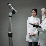 Pesquisadores analisam um sistema robótico em um laboratório.