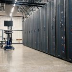 Armários metálicos com servidores, equipamentos de rede e cabos em um datacenter moderno