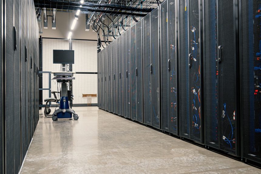 Armários metálicos com servidores, equipamentos de rede e cabos em um datacenter moderno